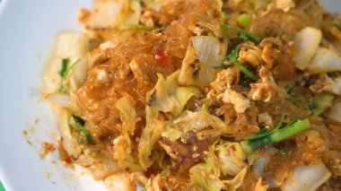 Kızarmış sukiyaki, yumurta ve domuz etini beyaz tabakta karıştırın.