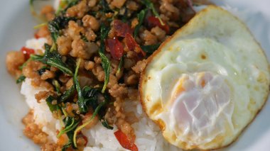 Kızarmış domuz eti, kutsal fesleğen ve pilavın üstünde kızarmış yumurta.