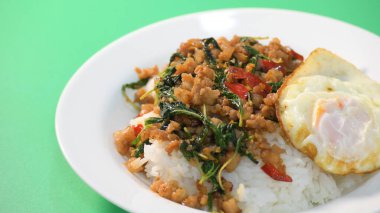 Kızarmış domuz eti, kutsal fesleğen ve pilavın üstünde kızarmış yumurta.