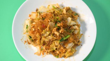 Kızarmış sukiyaki, yumurta ve domuz etini beyaz tabakta karıştırın.