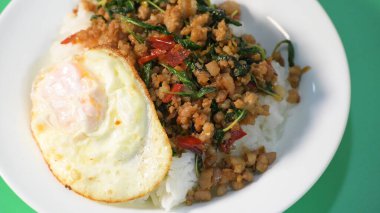 stir fried pork with holy basil on top with fried egg on cooked rice clipart