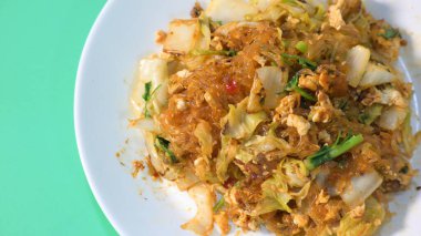 Kızarmış sukiyaki, yumurta ve domuz etini beyaz tabakta karıştırın.