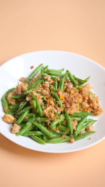 Beyaz tabakta kızarmış yeşil fasulye, Tayland yemeği ve Çin yemeği.