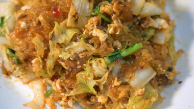 Kızarmış sukiyaki, yumurta ve domuz etini beyaz tabakta karıştırın.