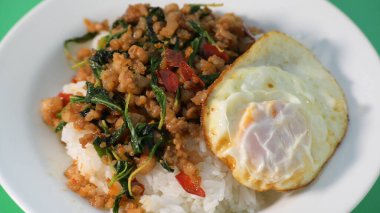 Kızarmış domuz eti, kutsal fesleğen ve pilavın üstünde kızarmış yumurta.