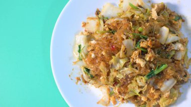 Kızarmış sukiyaki, yumurta ve domuz etini beyaz tabakta karıştırın.