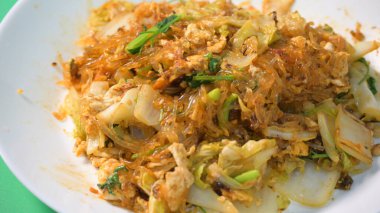 Kızarmış sukiyaki, yumurta ve domuz etini beyaz tabakta karıştırın.