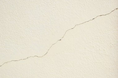 Beyaz duvarda deprem ve inşaat endüstrisinden çatlaklar var.