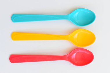 Beyaz arka planda izole edilmiş renkli kaşık, piknik için plastik çatal bıçak takımı