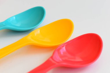 Beyaz arka planda izole edilmiş renkli kaşık, piknik için plastik çatal bıçak takımı