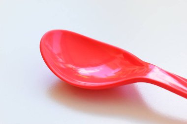 Kırmızı kaşık beyaz arka planda izole edilmiş, plastik çatal bıçak takımı piknik için.