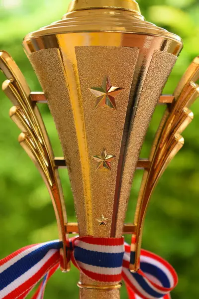 Yeşil ağaç zemininde Tayland ve kurdeleli güzel altın kupa