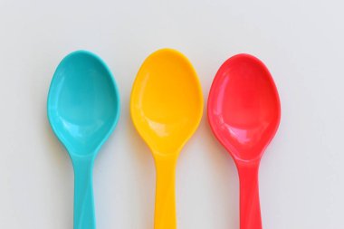 Beyaz arka planda izole edilmiş renkli kaşık, piknik için plastik çatal bıçak takımı