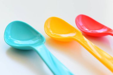 Beyaz arka planda izole edilmiş renkli kaşık, piknik için plastik çatal bıçak takımı