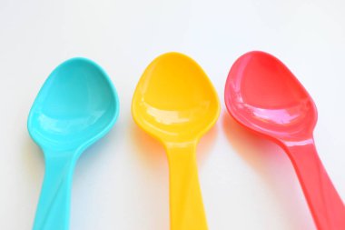 Beyaz arka planda izole edilmiş renkli kaşık, piknik için plastik çatal bıçak takımı