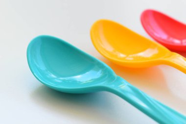 Beyaz arka planda izole edilmiş renkli kaşık, piknik için plastik çatal bıçak takımı