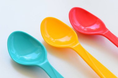 Beyaz arka planda izole edilmiş renkli kaşık, piknik için plastik çatal bıçak takımı