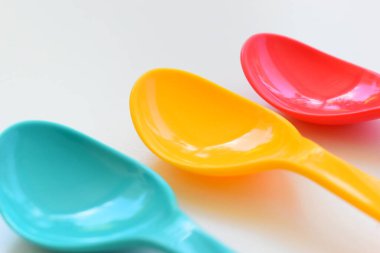 Beyaz arka planda izole edilmiş renkli kaşık, piknik için plastik çatal bıçak takımı