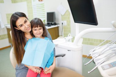 Mutlu aile annesi ve kızı dişçi ofisinde.