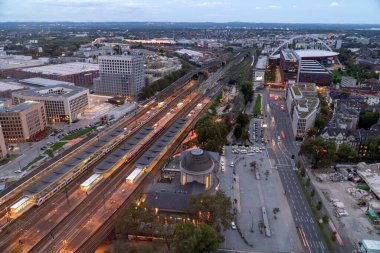 Köln istasyonu Koln Messe Deutz 'un akşam hava manzarası ve aydınlatılmış demiryolu rayları