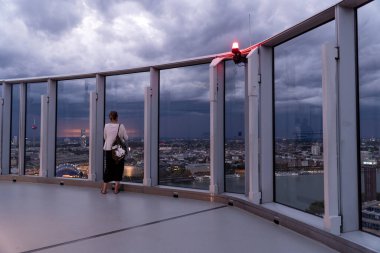 Köln Üçgeni gözlem güvertesinden bir kadın Köln şehrine bakıyor.
