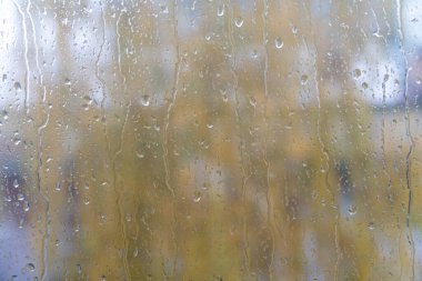 Pencere camına yağmur damlası. Pencerenin dışındaki bulanık arkaplan