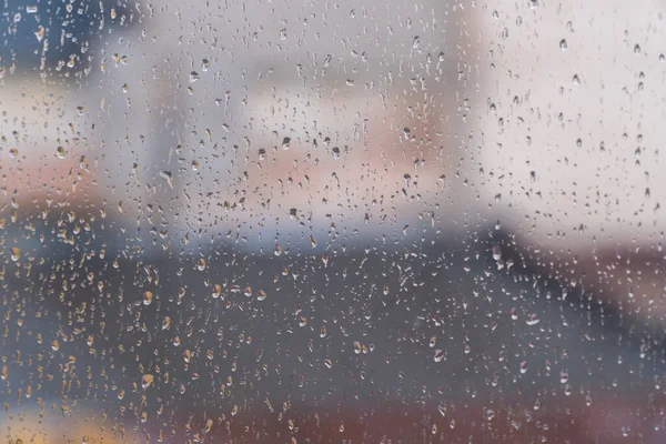 Pencere camına yağmur damlası. Pencerenin dışındaki bulanık arkaplan