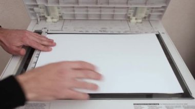 Bir ofis çalışanı tarayıcıdaki A3 kağıdını tarıyor.