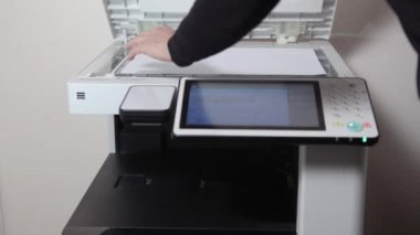 Bir ofis çalışanı, MFP ofisinin A3 kağıdını kopyalıyor.