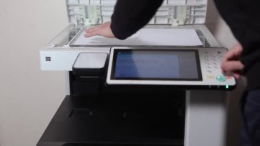 Bir ofis çalışanı, MFP ofisinin A3 kağıdını kopyalıyor.