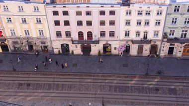 Lviv 'in ana meydanından bak. İnsanlar eski kasabada yürüyorlar. Avrupa şehrinin büyülü atmosferi.