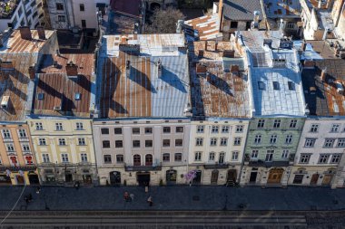 Lviv 'in ana meydanından bak. İnsanlar eski kasabada yürüyorlar. Avrupa şehrinin büyülü atmosferi.