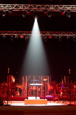 Sahne ışıklandırması. Sahne ışığı bir konser sırasında sahnede. Orkestra şefinin müzik standı. Müzik aletleri. Kırmızı ışık