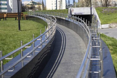 Bir kaldırım boyunca yer alan ve yayalar için hem güvenli hem de estetik cazibe sağlayan cilalı paslanmaz çelik korkuluklar.