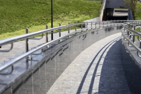 Bir kaldırım boyunca yer alan ve yayalar için hem güvenli hem de estetik cazibe sağlayan cilalı paslanmaz çelik korkuluklar.