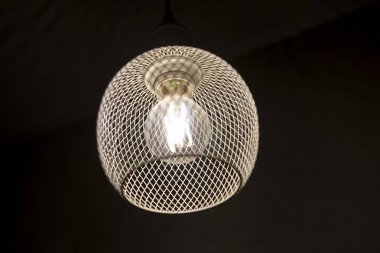 Koyu arkaplanda ampul olan desenli bir avize.