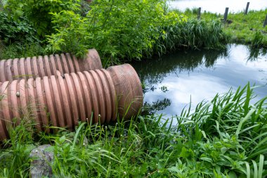 Molozların beton borusu, suyun doğaya aktığı yer. Atık su, toplayıcı, çevre kirliliği. Bahar, dere, drenaj borusu.