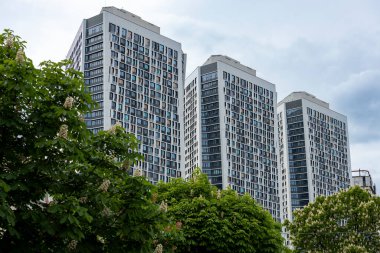 Önlerinde bulunan yemyeşil çiçek açan kestane ağaçlarının zemininde gururla duran yüksek binalar manzaranın güzelliğini artırıyor..