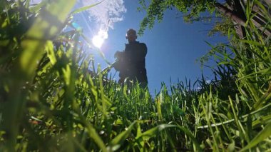 Bahçesinde çim biçen bir adam.