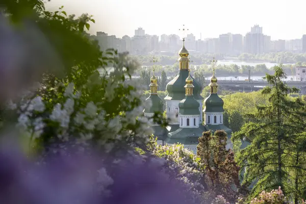 Altın kubbeleri olan güzel bir kilise yumuşak bir leylak gökyüzüne karşı zarif bir şekilde yükselir. Süslü ayrıntıları ışıkta parlar. Huzurla çevrelenmiş, huzur, maneviyat ve sonsuz zarafet yayıyor..