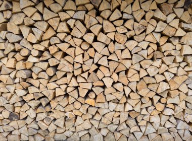 Farklı boyutlardaki kütüklerin kesit arkaplanı. Ağaç kabuğu, çatlak ve doku ile kesilmiş kahverengi kütüklerden oluşan bir duvar. Ağaç gövdesini kes. Yakacak odun, kütük, kereste. Ahşap arkaplan deseni.