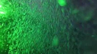 Kabarcıklar parlak ve renkli ışıklarla aydınlatılan parlayan havuz suyunda kaotik bir şekilde hareket ederler. Parlayan yansımalar soyut, rüya gibi bir model yaratır, hareket, ışık ve sıvıyı büyüleyici bir görsel ekrana karıştırır.