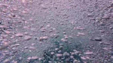 Güneş ışığında havuz suyunda baloncukların kaotik hareketi. Soyut mavi arkaplan