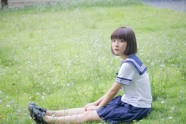 日本十多岁的漂亮女孩在学生们的微笑和放松 免版税图库图片