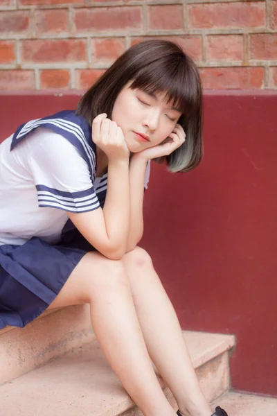 日本十多岁的漂亮女孩在学生们的微笑和放松 图库照片