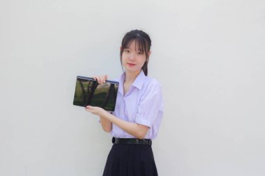 Asya Thai lisesi üniforması güzel kız tabletini göster