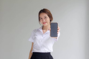 Taylandlı yetişkin üniversite üniforması güzel kız telefonunu göster ve gülümse.