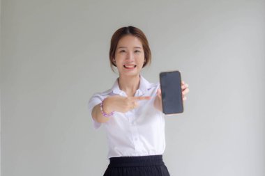 Taylandlı yetişkin üniversite üniforması güzel kız telefonunu göster ve gülümse.