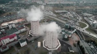 Büyük bir şehirdeki sanayi bölgesinin havadan görüntüsü. Termik santralin bacaları havaya buhar ve duman salıyor ve çevreyi kirletiyor. Yüksek kalite 4k görüntü