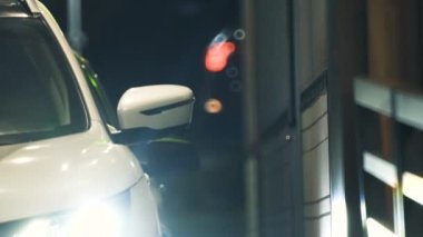 Polonya - Wroclaw, 17 Nisan 2023. Otomobil sürücüsü, geceleri şehirdeki bir fast food restoranında sipariş vermek için satıcıdan yiyecek alıyor. Yüksek kalite 4k görüntü